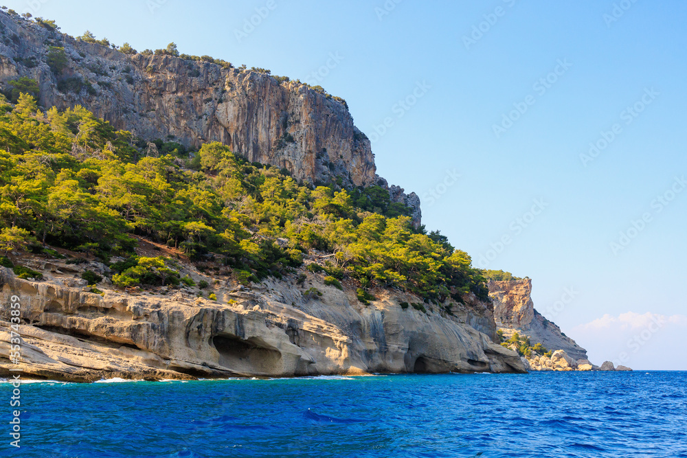 View of the rocky shore from the sea. Mediterranean Sea in Turkey. Popular tourist places. Background View of the rocky shore from the sea. Mediterranean Sea in Turkey. Popular tourist places. Background