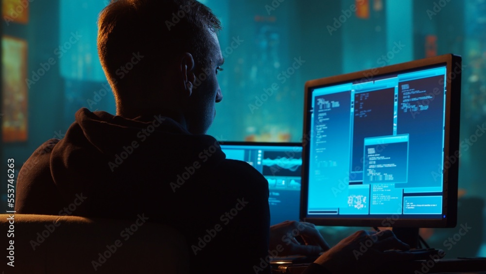 Computer Hacker in Hoodie. Obscured Dark Face. Concept of Hacker Attack, Virus Infected Software, Dark Web and Cyber Security. Computer Hacker in Hoodie. Obscured Dark Face. Concept of Hacker Attack, Virus Infected Software, Dark Web and Cyber Security.