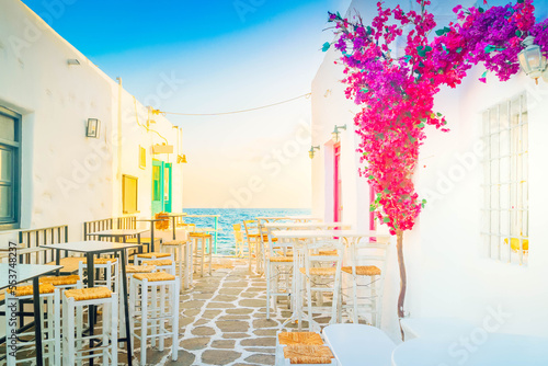 Fototapeta Naklejka Na Ścianę i Meble -  Naoussa typical white street leading to sea with sunshine, small village on Paros island, Greece, toned
