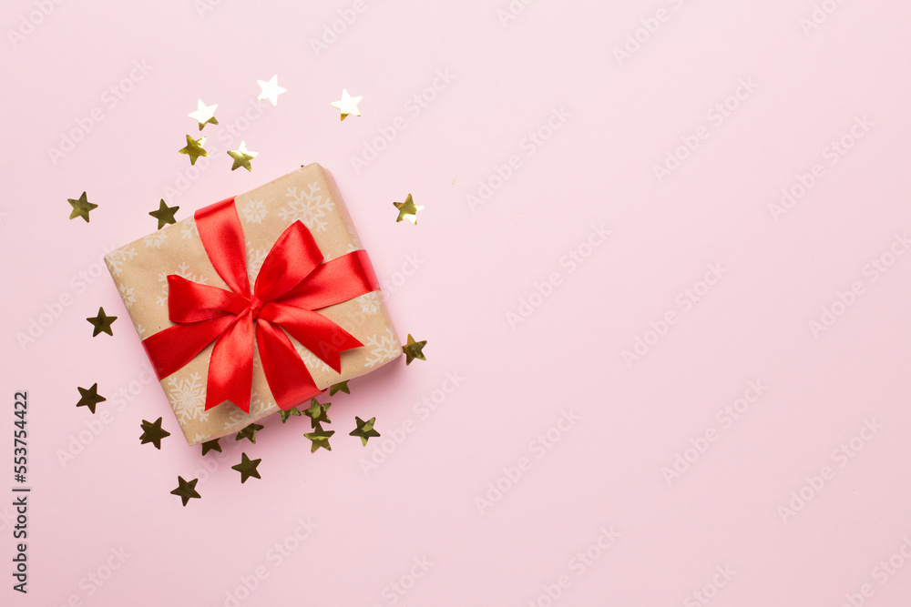 Gift box and stars confetti on color background, top view Gift box and stars confetti on color background, top view