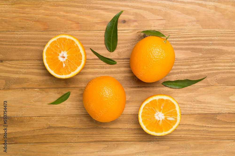 Flat lay with fresh oranges and leaves on wooden background Flat lay with fresh oranges and leaves on wooden background
