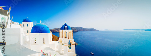 traditional greek village Oia of Santorini, with blue domes against sea and caldera, Greece, web banner, toned