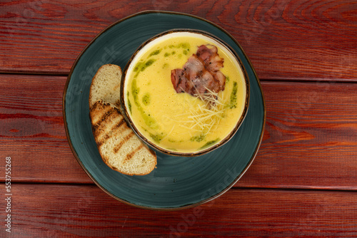 cream soup with bacon in a cup on a wooden table