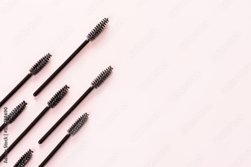 Set of brushes for eyelashes and eyebrows on pink background. Correction and care. Cooling and laying. Womens cosmetics. Set of brushes for eyelashes and eyebrows on pink background. Correction and care. Cooling and laying. Womens cosmetics.
