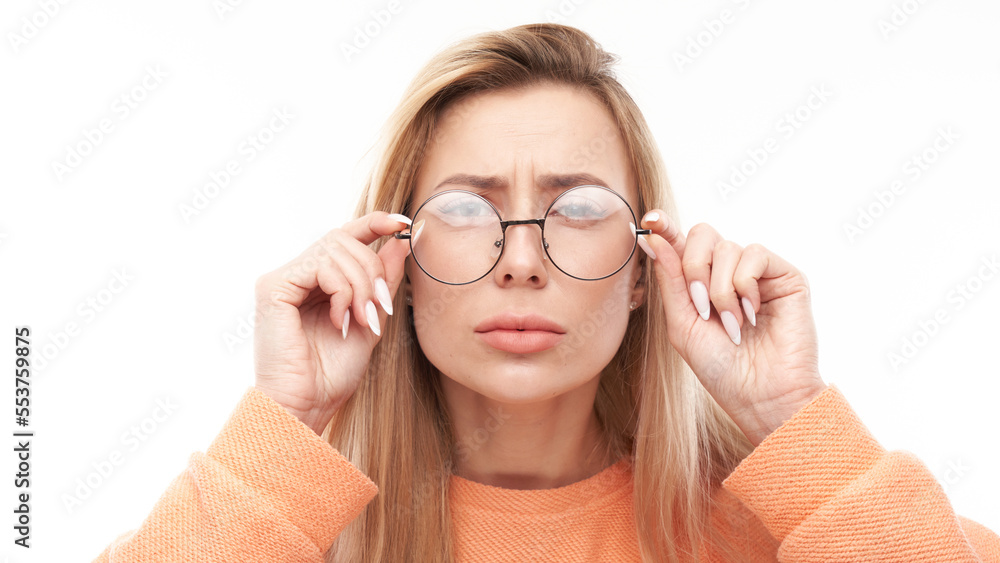 Blonde young woman wearing glasses squinting while looking at camera isolated on white background. Vision problems concept - obrazy, fototapety, plakaty 