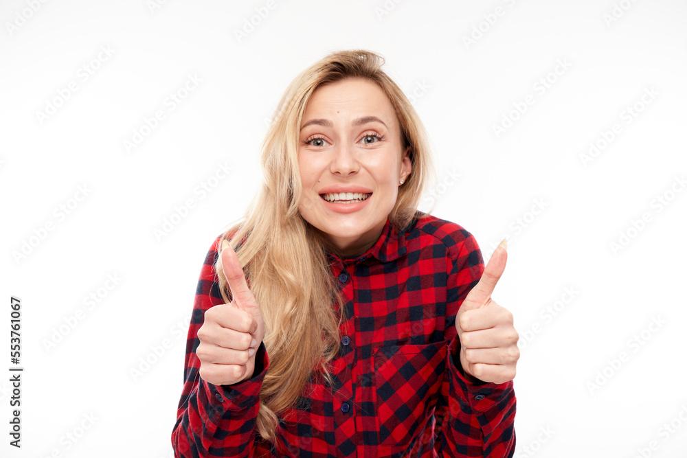 Happy blonde girl shows hand with thumbs up and smiles at the camera isolated on white background Happy blonde girl shows hand with thumbs up and smiles at the camera isolated on white background