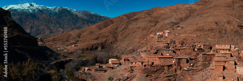 Panoramic view of Small village in the middle of Atlas mountains, Morocco with snow capped mountain in background photo