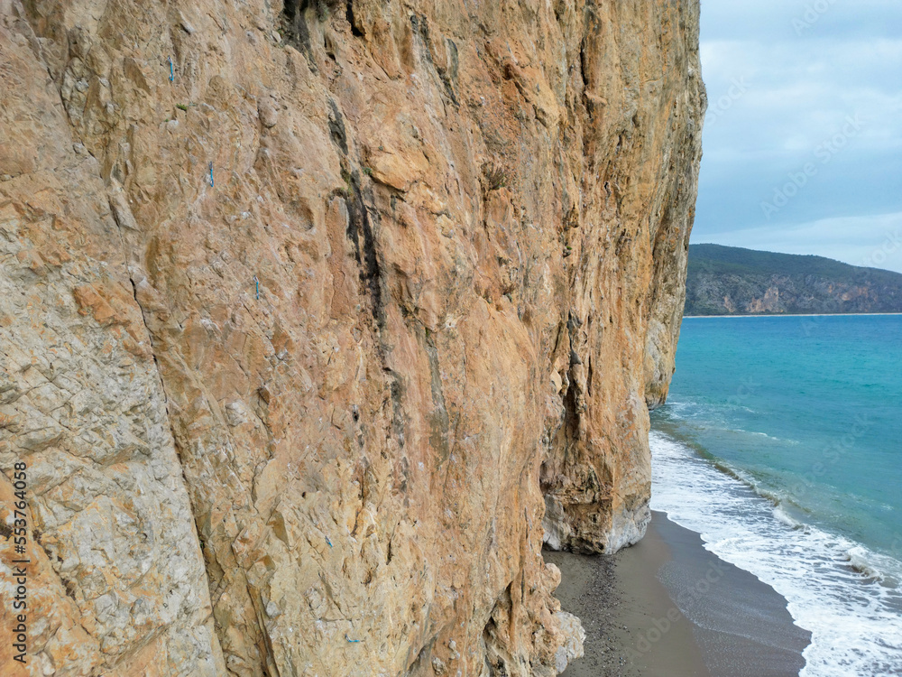 wonderful cliff in southern Italy (Campania region) in one of the most beautiful and isolated beaches of the peninsula. Beach with cliff at sunset bathed by a clear blue sea on a cloudy day.