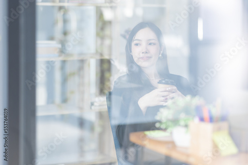 Free Download Happy Asian young woman drinking coffee while working online in office, employee freelance online marketing e-commerce telemarketing concept.
 - GFXLoad