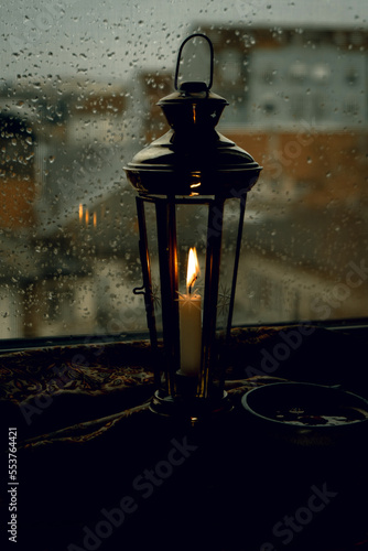 Candle light of old lantern with a rainy window view of Novi Sad Serbia