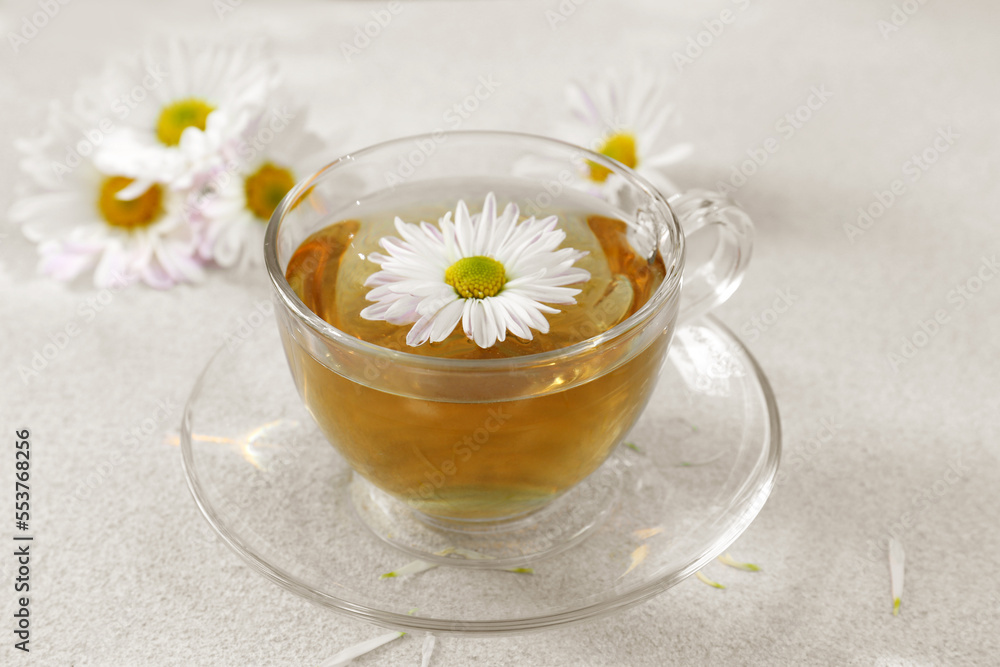 Glass cup of delicious chamomile tea on white table Glass cup of delicious chamomile tea on white table