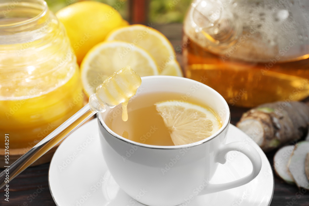 Cup of delicious tea with lemon and honey on wooden table, closeup Cup of delicious tea with lemon and honey on wooden table, closeup
