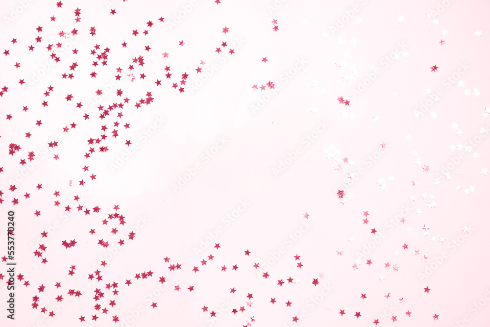 Christmas flat lay scene with scattered stars, top view over pink with copy space