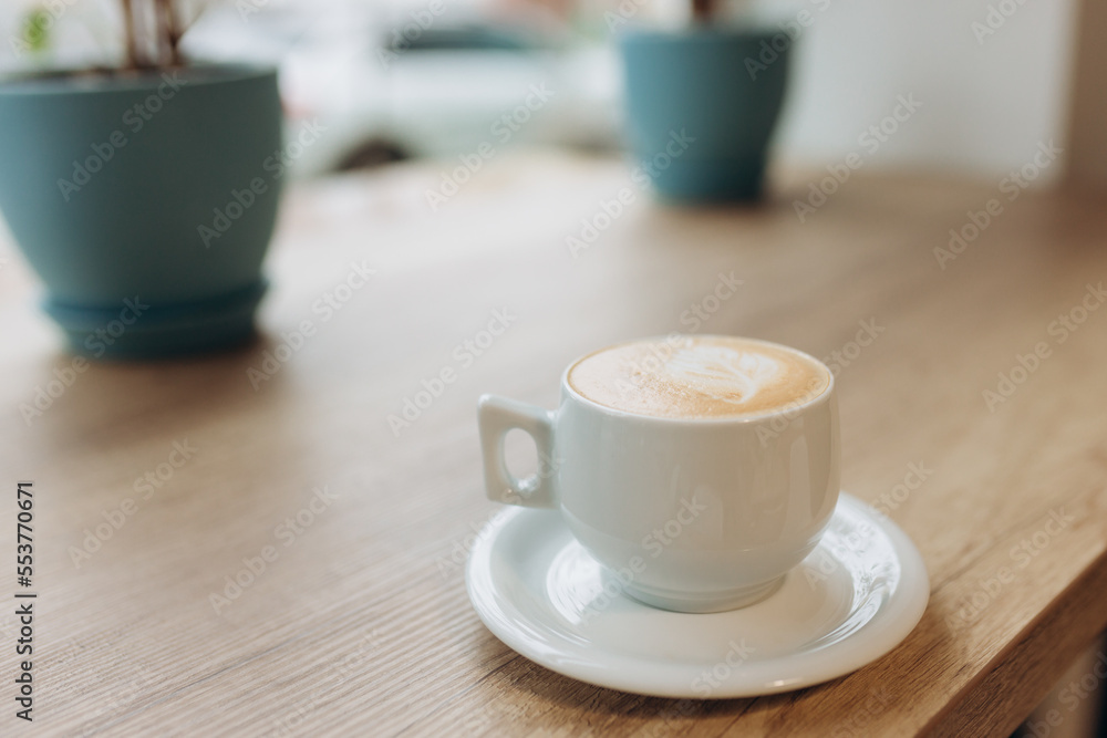 Cup of coffee with heart pattern in a white cup on wood table Cup of coffee with heart pattern in a white cup on wood table