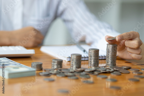 Growth investment success concept and financial planning. Businessman counting coins and banknotes by taking notes profit from doing business, saving money for the future and life after retirement.