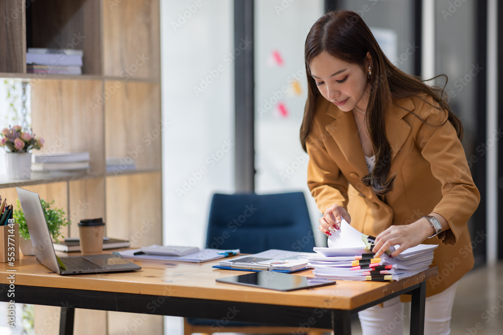 Boring young business Asian woman holding document file and work at office investment data report Financial and tax systems concept. Boring young business Asian woman holding document file and work at office investment data report Financial and tax systems concept.