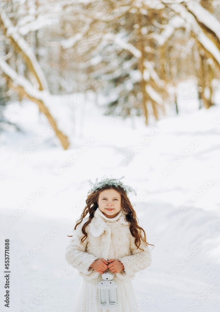 A little girl walks in a snowy park. A little girl walks in a snowy park.