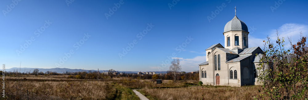 Fototapeta premium The church of the young generation on the horizon, a panorama of the autumn landscape.