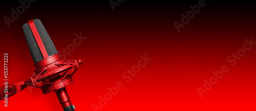 Recording studio microphone on red background with copy space for podcast or radio broadcast website banner