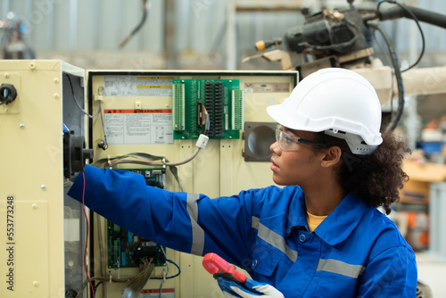 Experienced female electrical engineer The electrical system of the welding robot's electrical control system is being checked