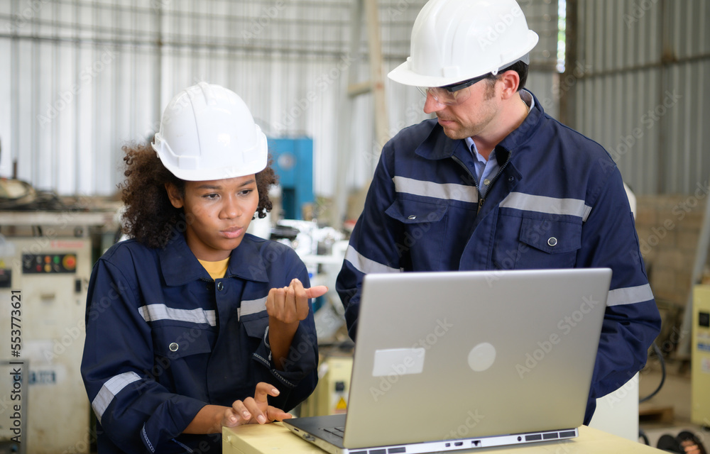 The two engineers check the operation of welding robots. ready to transfer and exchange experiences each other's skills The two engineers check the operation of welding robots. ready to transfer and exchange experiences each other's skills