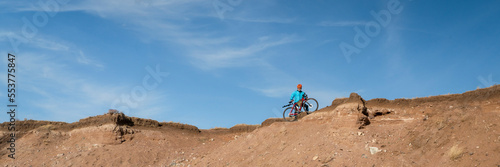male cyclist is riding a gravel bike on cliff edge in Colorado prairie - Soapstone Prairie Natural Area, panoramic web banner