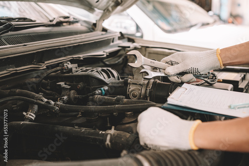 Automobile mechanic man checking car damage broken part condition, and repairing vehicle at home garage