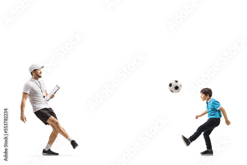 Football coach kicking a ball with a boy