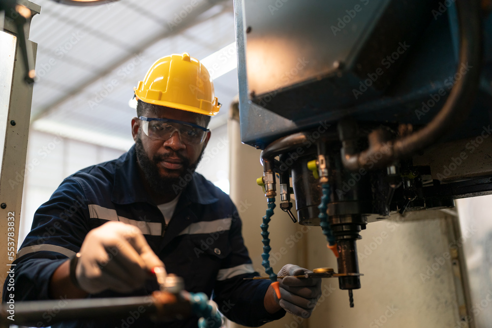 Robotics engineer fitting sensors to traditional engineering lathe in robotics research facility Robotics engineer fitting sensors to traditional engineering lathe in robotics research facility
