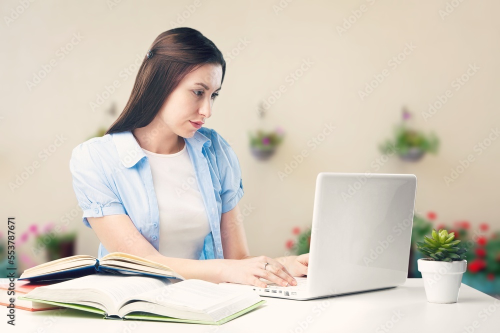 Serious young student studying with books and laptop Serious young student studying with books and laptop