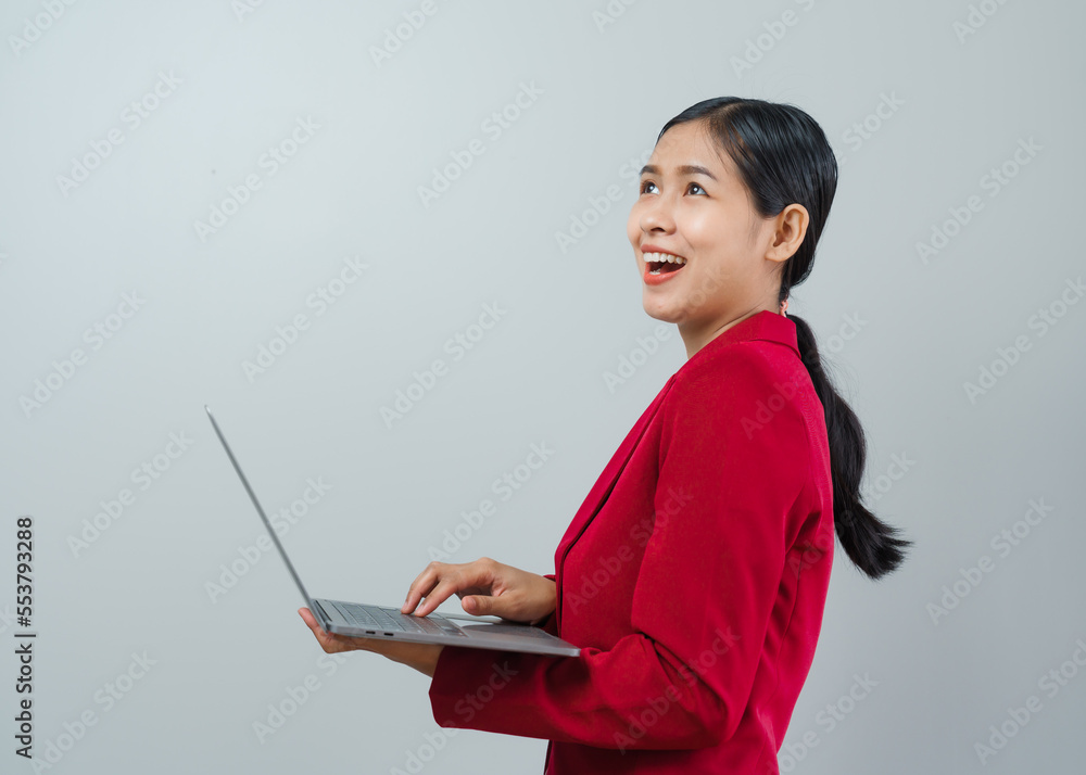 Pretty lovely manager lady successful business asian women in red suit isolated over background. Holding and using laptop computer Pretty lovely manager lady successful business asian women in red suit isolated over background. Holding and using laptop computer
