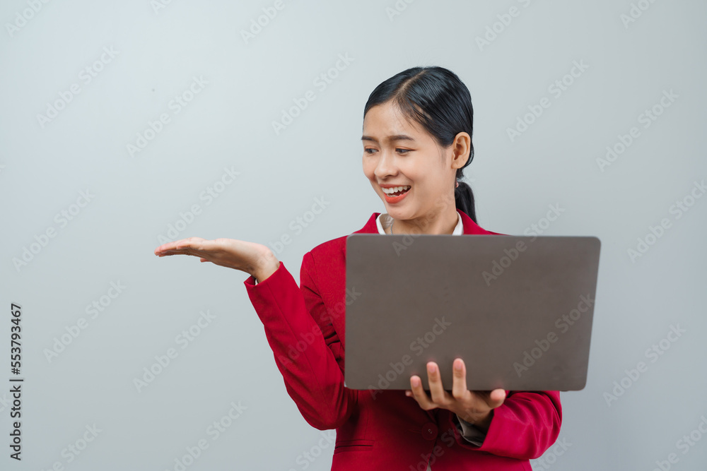 Pretty lovely manager lady successful business asian women in red suit isolated over background. Holding and using laptop computer Pretty lovely manager lady successful business asian women in red suit isolated over background. Holding and using laptop computer