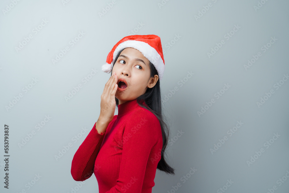 Pretty lovely lady asian thai women in red sweater and santa christmas hat isolated over grey background. thinking and surprise Pretty lovely lady asian thai women in red sweater and santa christmas hat isolated over grey background. thinking and surprise
