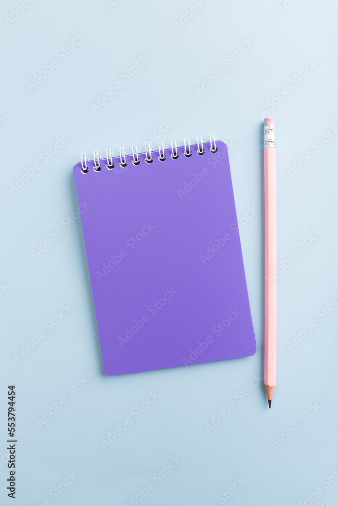 Purple notebook on a blue background with a pencil Purple notebook on a blue background with a pencil