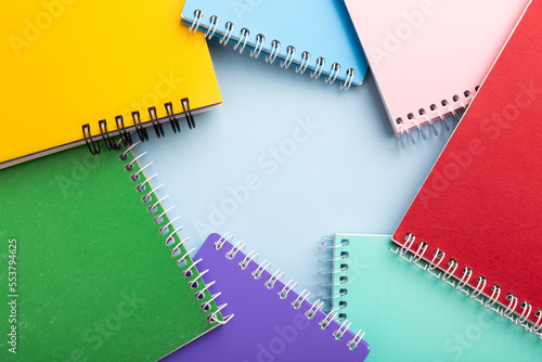 colored notebooks, colored pencils on a light table. Place for your text. © Alina Zavhorodnii