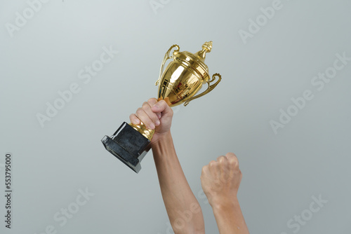 Close up man hands holding champion golden trophy isolated over background.