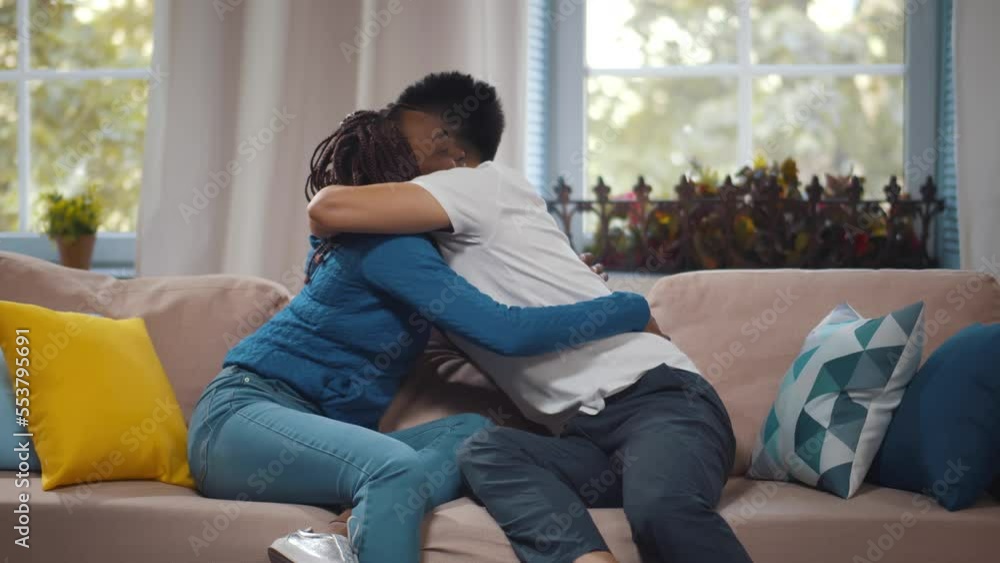 Multiethnic couple talk and hug on couch. Realtime Multiethnic couple talk and hug on couch. Realtime