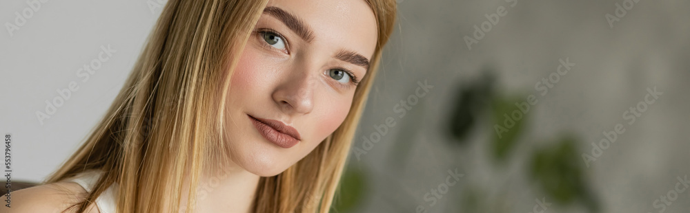 Portrait of young blonde woman looking at camera at home, banner. Portrait of young blonde woman looking at camera at home, banner.