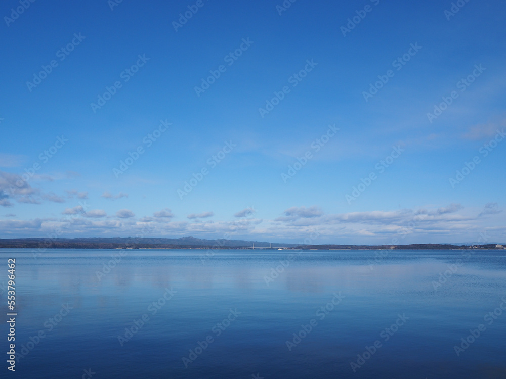 Calm, blue winter bay and blue sky
