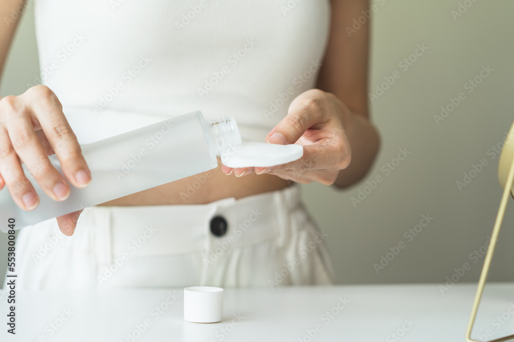 Close-up view hands of woman using toner and cotton pad to remove makeup Close-up view hands of woman using toner and cotton pad to remove makeup