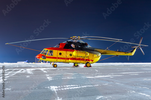 Medical helicopter on winter airport apron at night