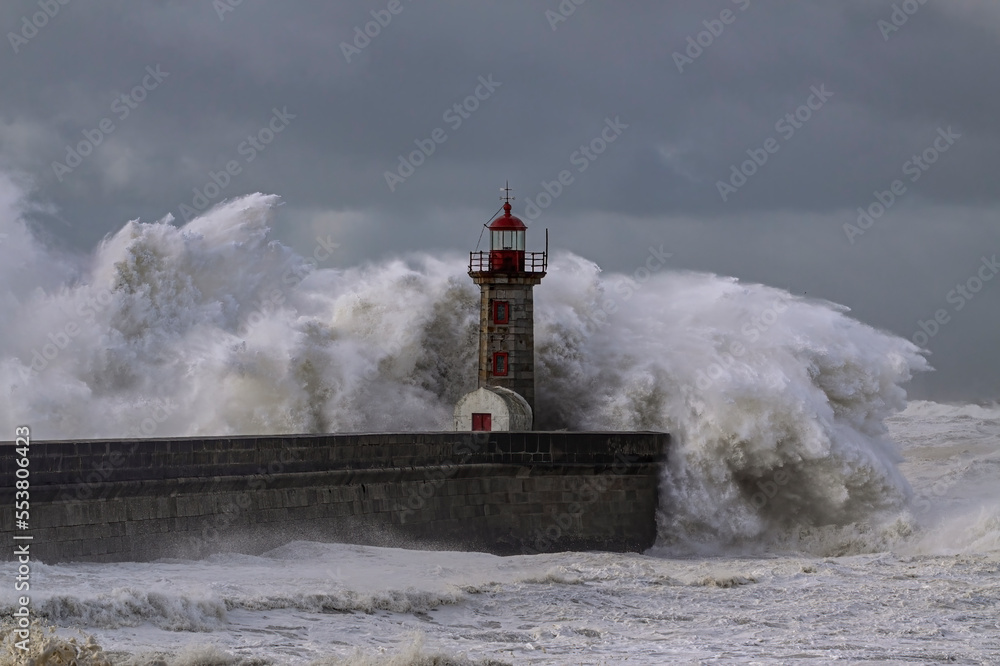 Huge stormy wave splash over old lighthouse