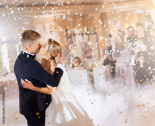 Brides Kissing And Hugging While Falling Confetti photo