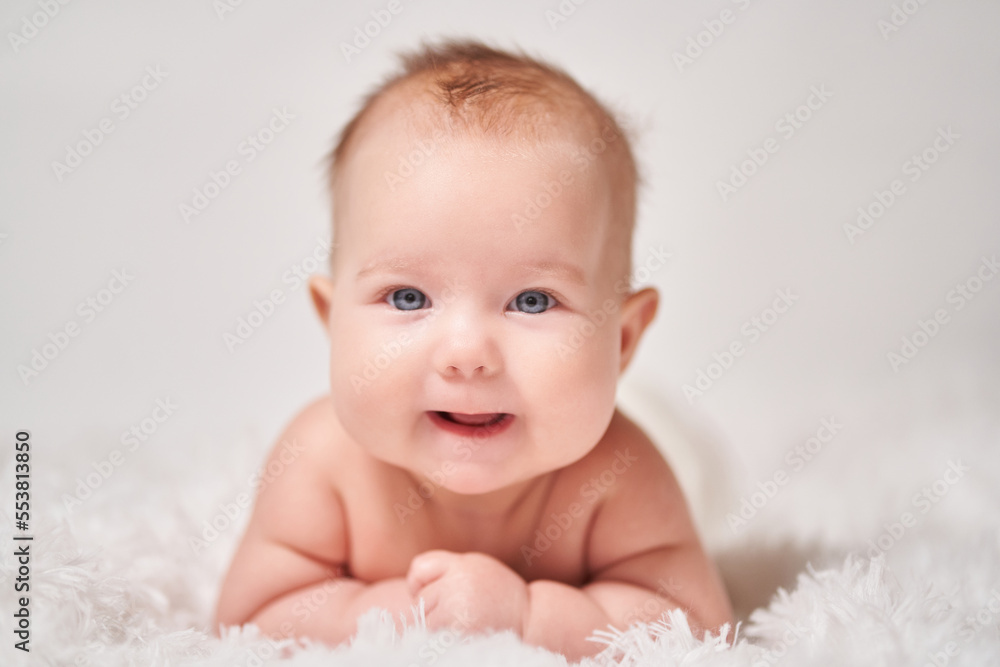 portrait of a smiling baby looking into the camera on a soft blanket portrait of a smiling baby looking into the camera on a soft blanket