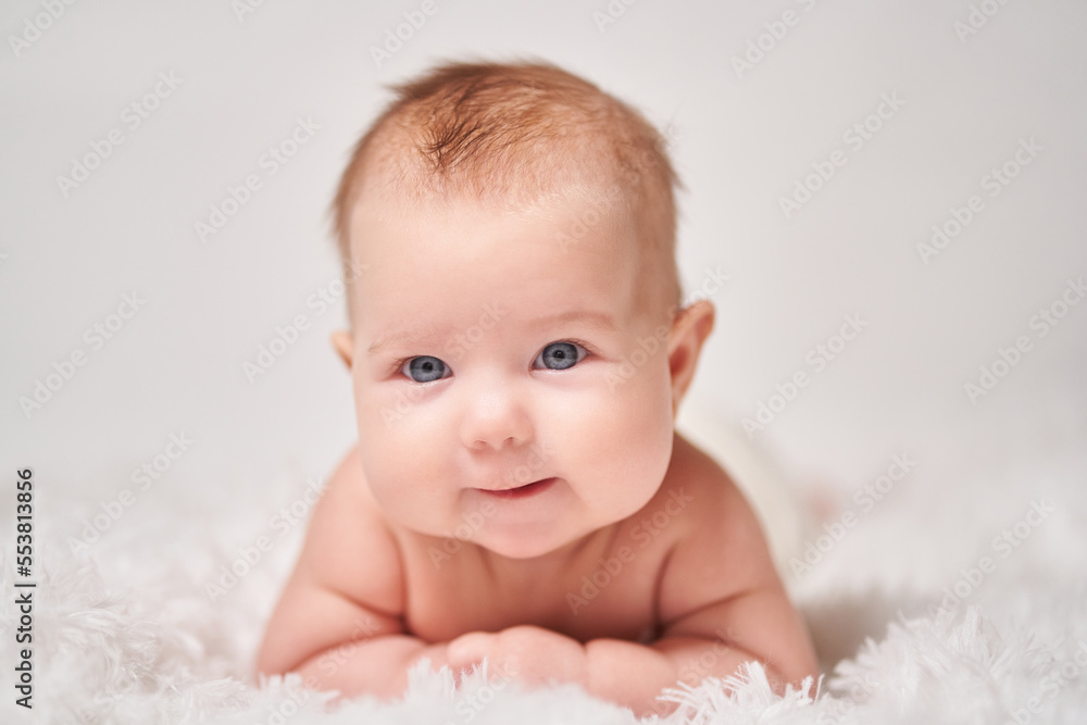portrait of a smiling baby looking into the camera on a soft blanket portrait of a smiling baby looking into the camera on a soft blanket