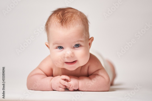portrait of a smiling baby on a white background looking into the camera