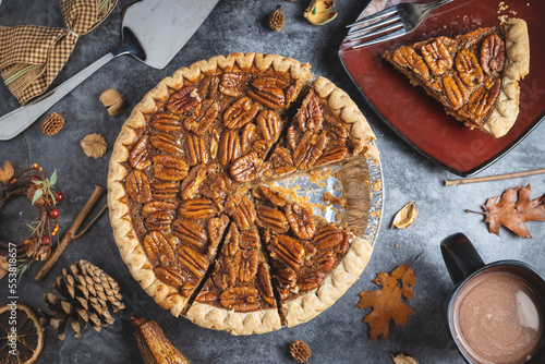 Top down pecan pie on a table with a mug of hot cocoa