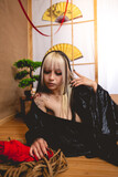 Beautiful, slim and young girl with blonde locks with a small and sexy black kimono and panties next to ropes for shibari in a traditional japanese room