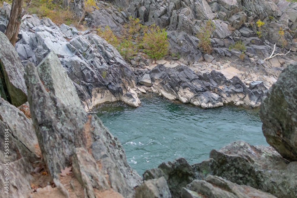 The rocky terrain and rushing rapids of Great Falls Park in Virginia as seen on a cloudy day.