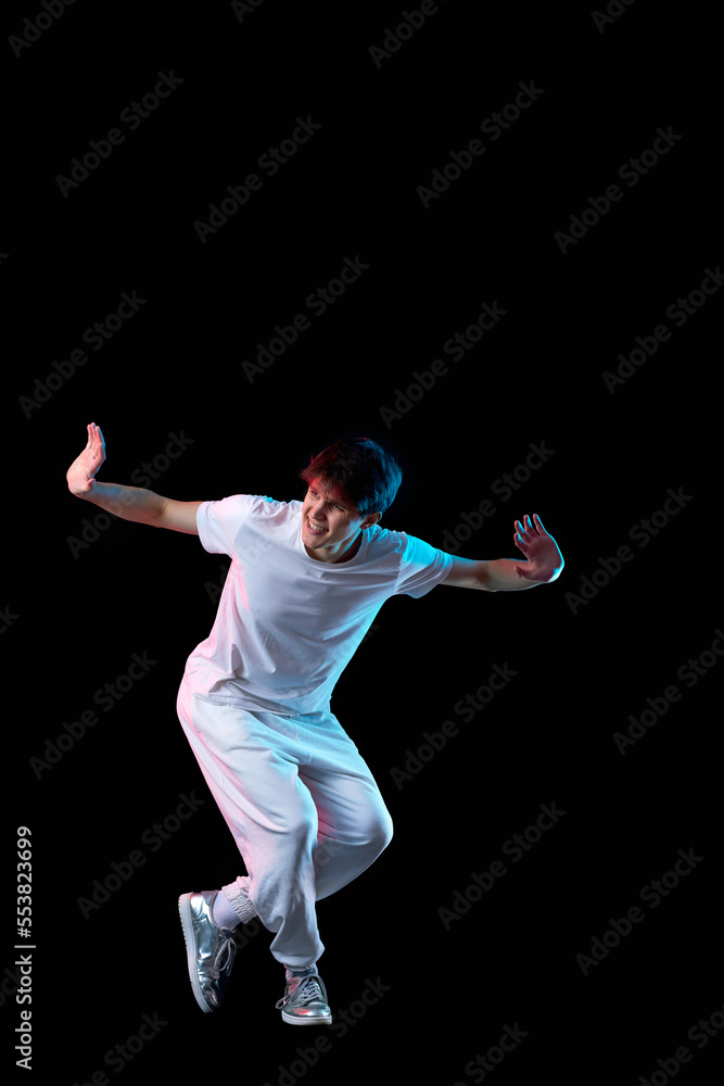 young man in black t-shirt and jeans dancing young man in black t-shirt and jeans dancing